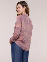 Camisa liviana de rayón y poliéster color marrón con estampado de hojas, cuello camisero, bolsillos frontales con solapa y manga larga.