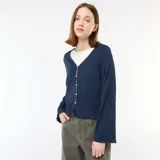 Top de punto con textura arrugada, color azul, con escote en pico y cierre frontal con botones pequeños. Presenta mangas largas con diseño acampanado.