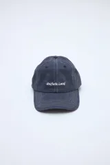 Gorra azul oscuro con efecto lavado, costuras pespunteadas en color blanco y texto bordado en el frente.