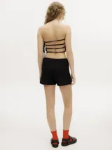 Top strapless tipo crochet color negro, de diseño tejido con detalles en ochos y puntos calados, con espalda descubierta y tiras ajustables en el lateral.