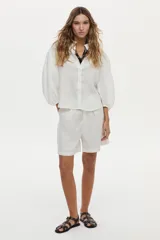 Camisa de lino blanca con mangas abullonadas y diseño para anudar al frente.