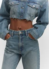 Jeans de tiro alto con corte mom-fit, confeccionados en tejido de algodón estilo tejano. Presentan diseño de cinco bolsillos, trabillas para cinturón y cierre frontal con cremallera y botón.