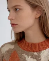 Buzo de tejido jacquard hecho a mano en mezcla de lana merino y seda, con diseño de formas orgánicas en tres colores. Presenta un calce relajado, cuello alto y terminaciones tejidas en rib.