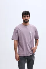 Remera oversize de algodón color lila con efecto lavado y estampa botánica pequeña en el pecho.