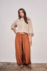Cardigan de algodón peinado color beige, con cuello camisero, cierre frontal de botones y detalles de textura en crochet con diseño de flores. Mangas tres cuartos y diseño corto.
