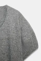 Jersey de punto de corte amplio, con escote redondo y mangas cortas con diseño holgado.