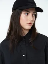 Conjunto compuesto por una camisa de manga larga con botones frontales y un short con cintura elástica y cordón ajustable, ambos en color negro.