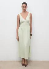Vestido largo color verde menta, sin mangas, con escote en V, tirantes anchos y detalles de encaje transparente en el pecho y la cintura. Presenta un diseño evasé de caída fluida.