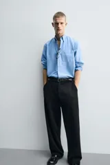 Pantalón de corte wide fit confeccionado en pana de algodón color marrón oscuro. Presenta bolsillos frontales, bolsillos traseros de vivo con botón y cierre frontal con cremallera y botón.