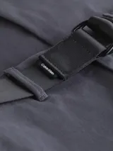 Pantalón chino de sarga elástica, corte slim y talle medio, color gris oscuro. Incluye un cinturón negro con hebilla metálica en forma de D.