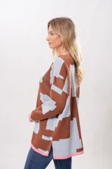 Buzo oversize de algodón con estampado geométrico en tonos marrones y celestes, con cuello y puños en color rosa.