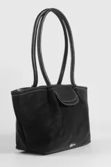 Cartera de cuero sintético marrón oscuro con doble asa larga de hombro, solapa frontal contrastante en tono marrón y detalles de costuras visibles.