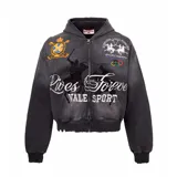 Campera con capucha y cierre frontal, de corte boxy y efecto desgastado. Presenta múltiples parches bordados y estampados con motivos deportivos, incluyendo gráficos de polo y anillos olímpicos.