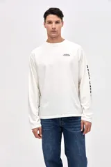 Remera manga larga de algodón lavado con textura suave, color gris oscuro, con estampado pequeño en el pecho y estampado en la manga.