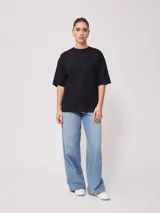 Remera negra de algodón con corte oversize y cuello redondo.