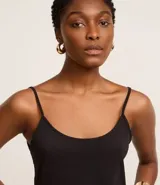 Blusa básica negra de breteles finos, confeccionada en malla de algodón peruano con escote redondo.