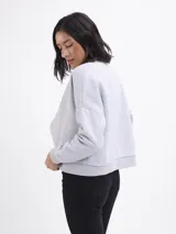 Campera tipo bomber de felpa color gris claro, con cierre frontal completo, cuello redondo y puños elásticos acanalados.