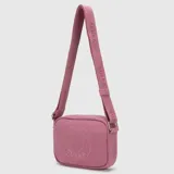 Bolso tipo bandolera de lona en color gris oscuro, con diseño compacto y cierre superior. Presenta un logo circular grabado en el frente y correa ajustable con el nombre de la marca.