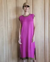 Vestido largo de punto sin mangas, color fucsia con una estrella blanca grande estampada en la espalda. Presenta detalles en color marrón en el cuello, las sisas y el ruedo, además de tajos laterales en la parte inferior.