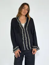 Saco color crudo con detalle de volados en el frente y puños.