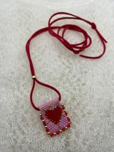 Collar con dije rectangular bordado con un corazón rojo y detalles de mostacillas de colores.