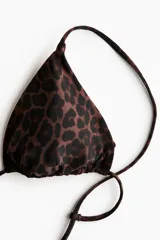 Top de bikini triangular con estampado de leopardo, copas con relleno extraíble y tirantes ajustables con lazo en la espalda.