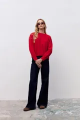 Sweater de punto color rojo, con cuello redondo, manga larga y puños acanalados.