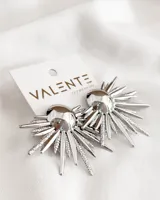 Aros plateados con forma de sol con centro circular y rayos texturizados.