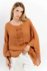 Blusa color rosa pálido de lino con mangas amplias y detalle de costuras en el frente.