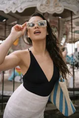 Malla enteriza color negro con escote profundo en V y breteles cruzados en la espalda. Confeccionada en tejido italiano de alta resistencia con protección UV+50.