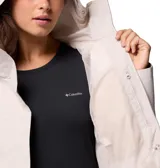 Campera impermeable Columbia modelo Hikebound II, color beige claro, con cuello alto, cierre frontal oculto y puños ajustables con velcro. Presenta el logo de la marca bordado en el pecho y tecnología Omni-Tech en la manga.