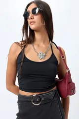 Minifalda tipo short pollera cruzada, color negro lavado, con cinturón integrado de denim y hebilla metálica redonda.