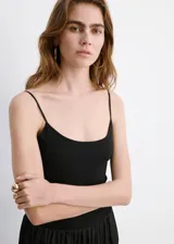 Vestido midi color negro con cuerpo ajustado de escote redondo y tirantes finos, combinado con una falda larga fruncida de tejido ligero y fluido.