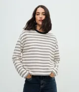 Blusa de corte oversize confeccionada en mezcla de algodón y poliéster, con estampado de rayas horizontales, cuello redondo en contraste y mangas largas.