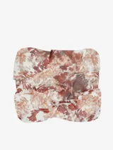 Pañuelo cuadrado de tela liviana con estampado multicolor en tonos marrones, blancos y naranjas con patrones geométricos y abstractos.