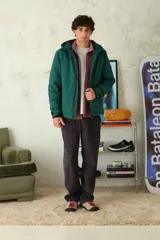 Campera técnica de color azul marino, con capucha integrada, cierre frontal termosellado y puños ajustables con velcro.