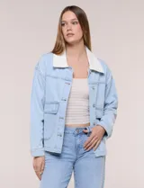 Campera de denim blanco de corte holgado con hombros caídos, cuello con solapa en contraste de color celeste, cierre frontal con botones metálicos y bolsillos delanteros con solapa.
