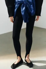 Zapato tipo bailarina deportiva de color negro, con suela de goma y detalle de lazo en la puntera redonda.