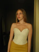 Top de cuero genuino color beige, con diseño plisado y escote corazón strapless.