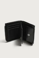 Tarjetero cuadrado de diseño minimalista en color negro, con cierre de cremallera metálica y dos ranuras internas para tarjetas.