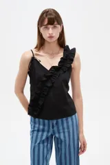 Musculosa de algodón color negro con escote en V profundo, tirantes finos y un volado diagonal fruncido que cruza desde el hombro izquierdo hasta el dobladillo.