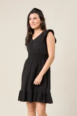 Vestido corto blanco con cuello en V, mangas cortas con volados, cintura elastizada y falda con volados.