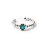 Aro trepador plateado con diseño de bolitas y una zirconia color turquesa engarzada en el centro.