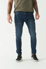 Jean skinny de hombre, color gris oscuro con efecto desgastado. Presenta cinco bolsillos, pasacinto y logo bordado.