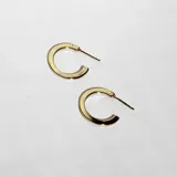 Par de aros tipo argolla abiertos, dorados, con pasante y diseño chato.