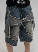 Bermuda de jean con diseño deconstruido y paneles superpuestos con bordes deshilachados. Presenta un efecto de lavado desgastado, cierre frontal y botones metálicos.