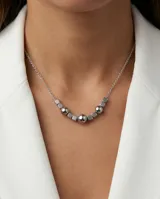 Collar de cadena fina de acero con diseño central compuesto por esferas y cubos metálicos intercalados.