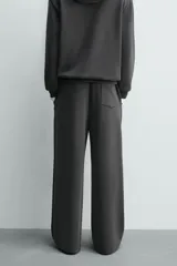 Pantalón jogger de corte wide fit confeccionado en tejido fluido con viscosa. Presenta un efecto lavado, cintura elástica ajustable con cordón, pliegues frontales, bolsillos laterales y un bolsillo trasero de plastrón.