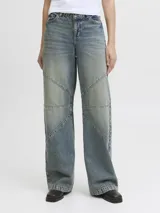 Jean wide fit de tiro medio, pierna curva y corte relajado, confeccionado en denim con lavado desgastado y costuras decorativas segmentadas.