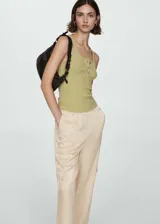 Pantalon de corte recto y diseño fluido, confeccionado en tejido satinado color beige. Cuenta con cintura elástica, bolsillos laterales, bolsillos cargo en las piernas y bolsillos de ribete en la parte posterior.